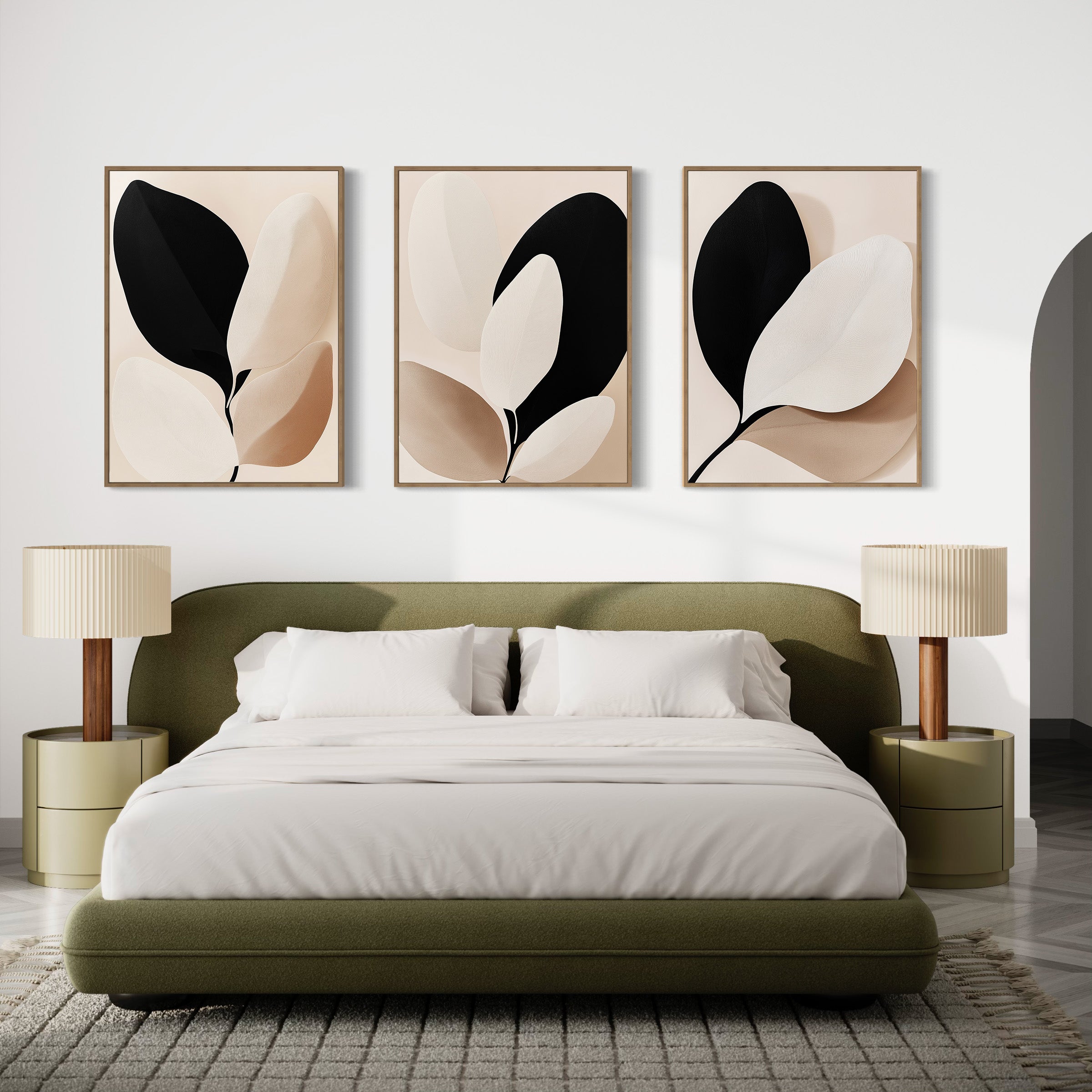 Modern bedroom with an olive green bed, white bedding, two round nightstands with beige lamps, and the Monochrome Flora Set of 3 botanical prints in neutral tones above the bed. A patterned rug covers the floor.