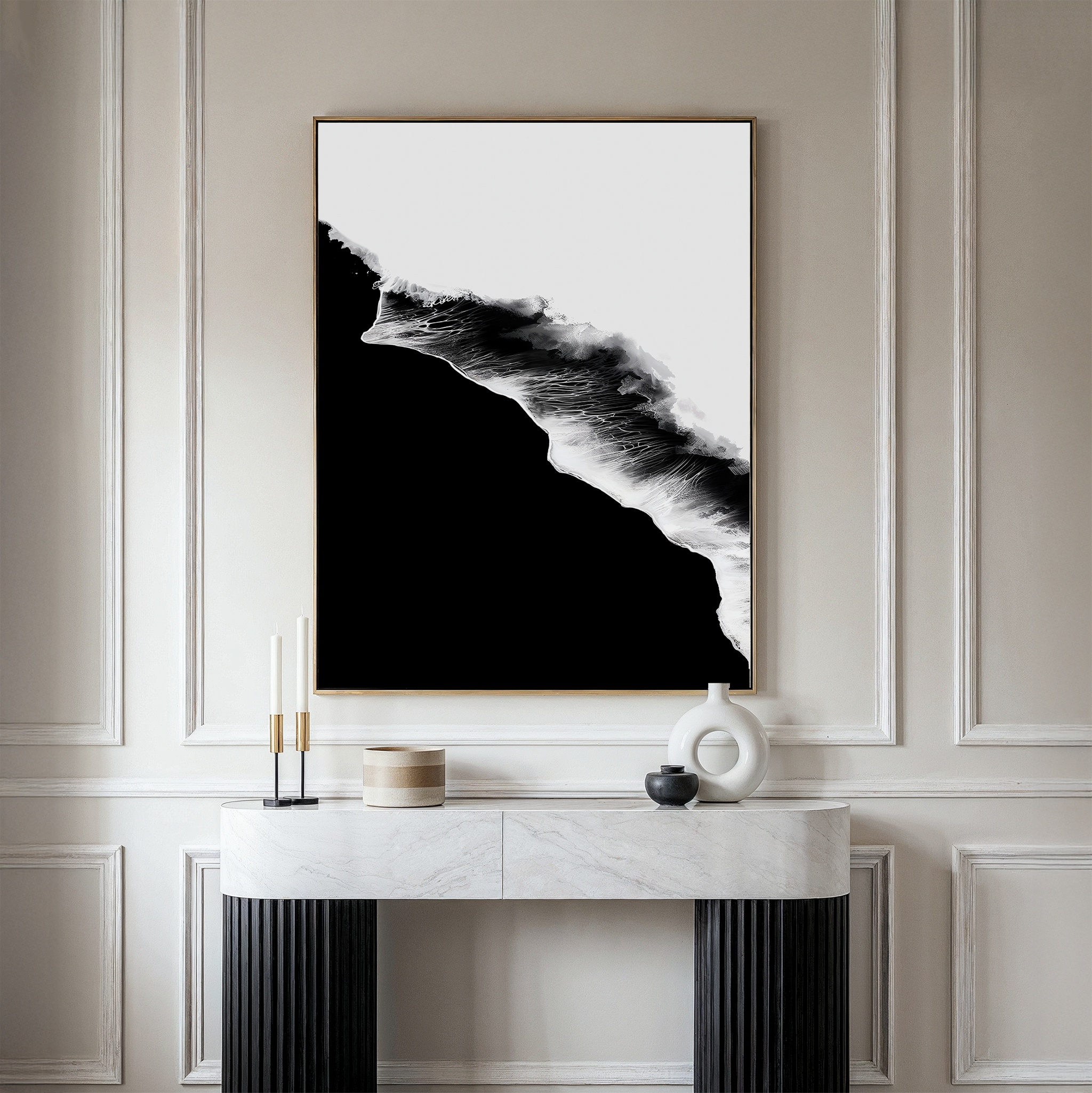 A modern interior features a marble console table with candles and ceramics, set below the Black Ocean Abstract Canvas Art, resembling ocean waves, against elegant light-colored paneled walls.