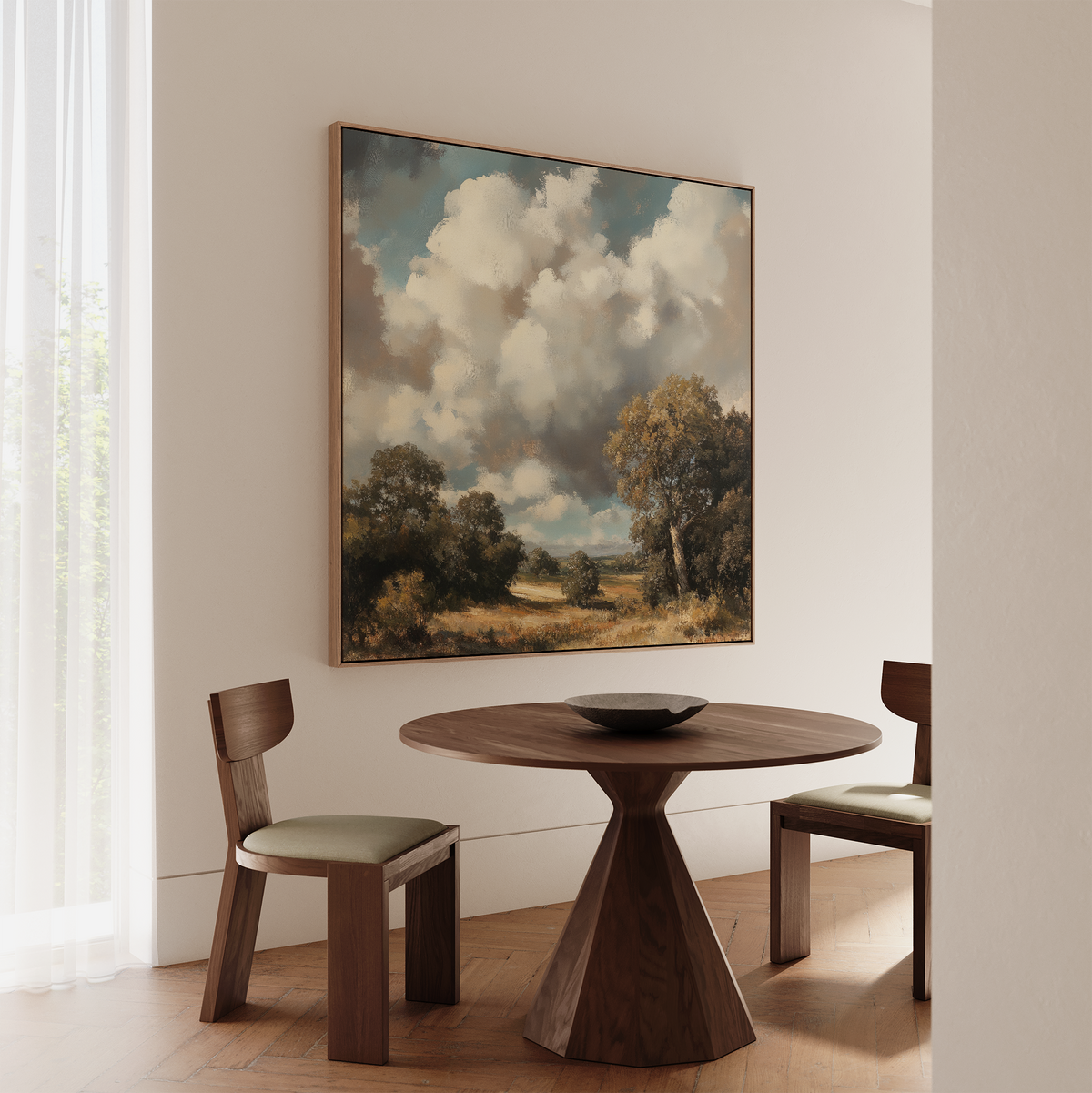 A round wooden table with two chairs sits in a minimalist room. Above, Gathering Storm Canvas Art adds atmosphere, while sunlight through sheer curtains enhances the cozy living room decor.