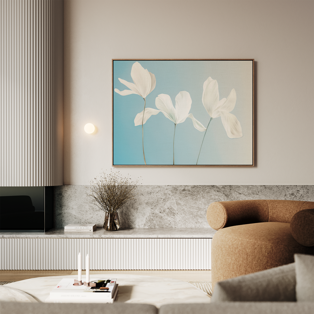 A modern living room with a neutral palette features minimalist wall art—Stellar Flora Abstract Canvas Art, a large white flower painting on blue—paired with a round brown armchair, coffee table, and decorative dried flowers in a vase.