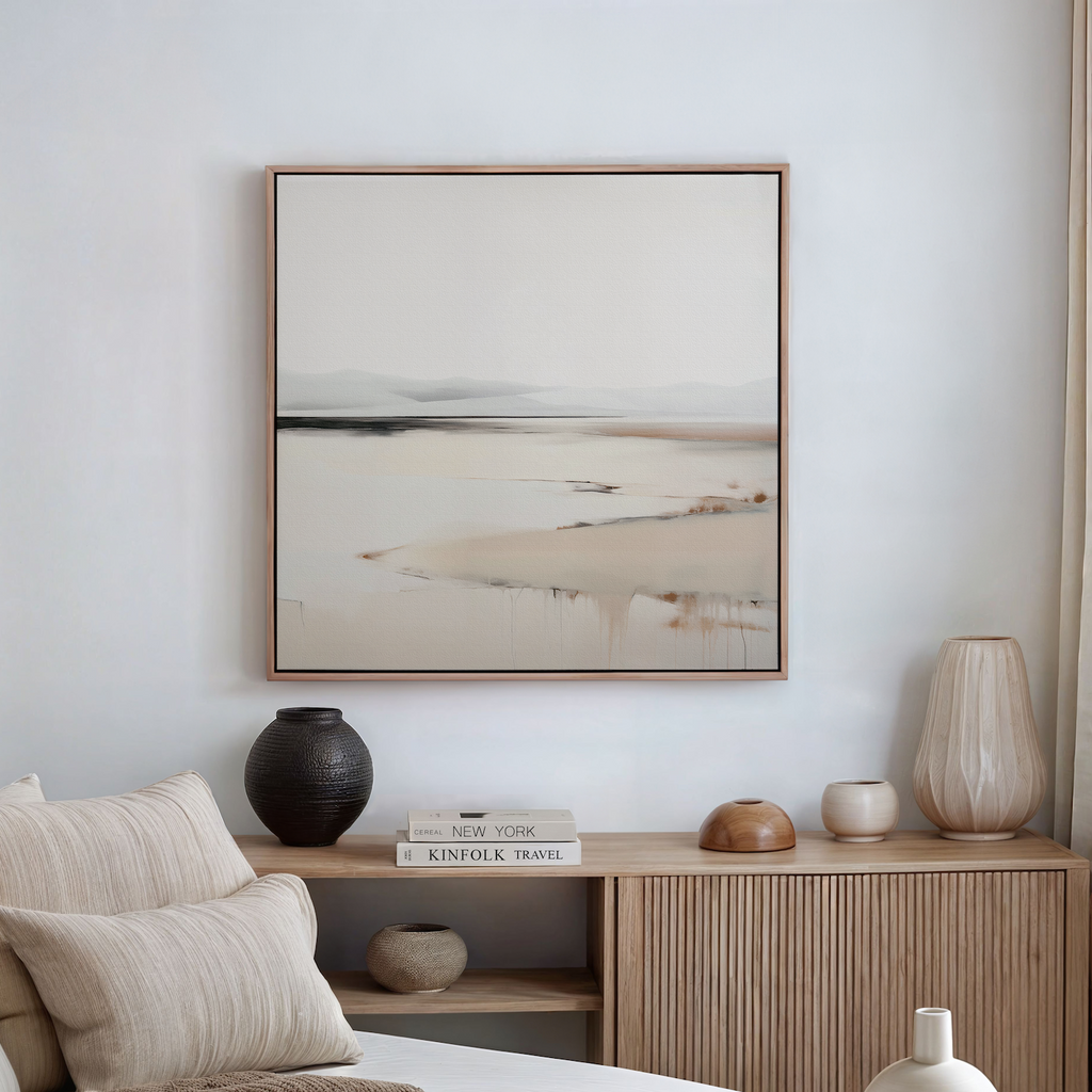 A minimalist bedroom scene with neutral tones features a wooden sideboard with vases, books, and decor. Above it hangs the Quiet Valley Abstract Canvas Art—a landscape painting in light, muted shades.