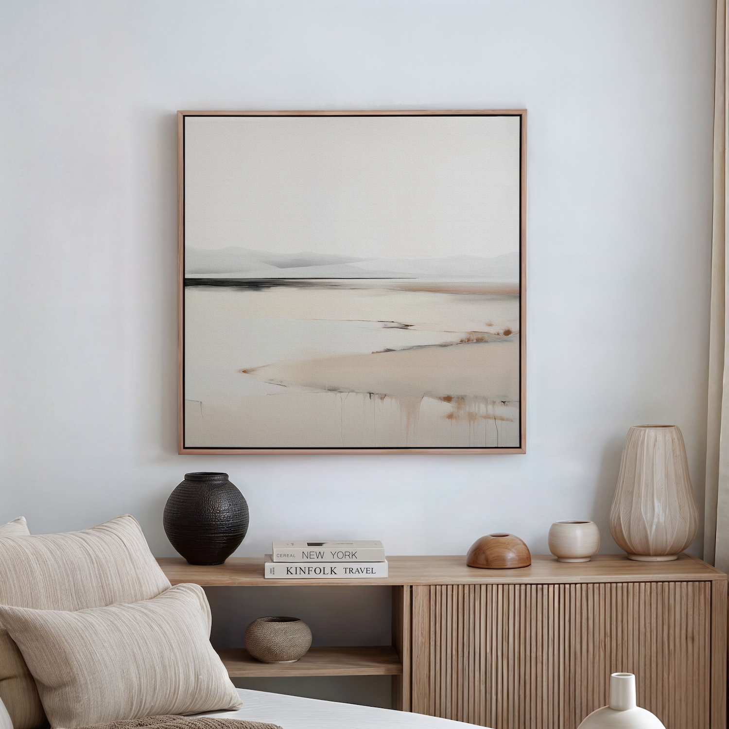A minimalist bedroom scene with neutral tones features a wooden sideboard with vases, books, and decor. Above it hangs the Quiet Valley Abstract Canvas Art—a landscape painting in light, muted shades.