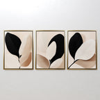 The Monochrome Flora Set of 3 features framed minimalist botanical prints in neutral black, beige, and cream tones—ideal for modern living room decor.