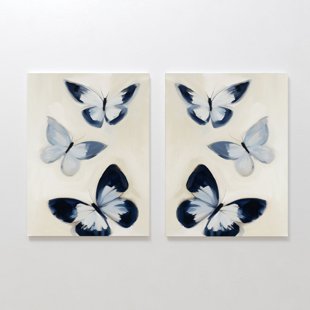 The Midnight Wings Set of 2 features abstract butterflies in soft blue, black, and white on beige canvas, bringing graceful movement and modern style to your wall decor.