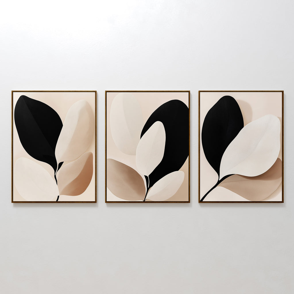 The Monochrome Flora Set of 3 features minimalist botanical wall art prints with abstract leaf designs in black, beige, and cream tones, each framed in thin wood—ideal for modern living room decor.