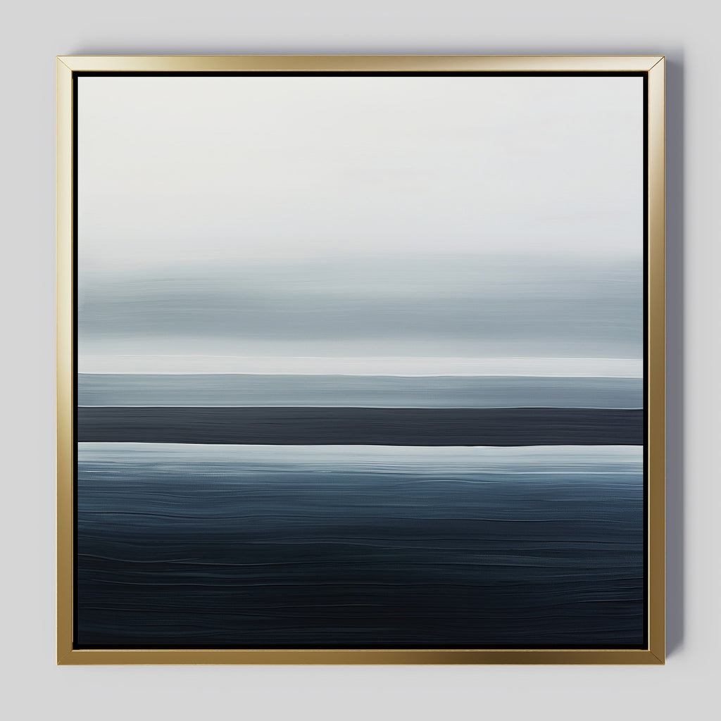 Oceanic Blur Abstract Canvas Art features horizontal blue and white gradients reminiscent of ocean waves and sky, set in a slim gold frame on a light gray background—ideal minimalist decor for a coastal-inspired living room.