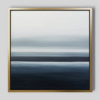 Oceanic Blur Abstract Canvas Art features horizontal blue and white gradients reminiscent of ocean waves and sky, set in a slim gold frame on a light gray background—ideal minimalist decor for a coastal-inspired living room.