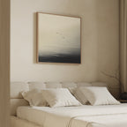 A minimalist bedroom showcases the Above the Calm Canvas Art above a beige bed with white pillows, depicting flying birds. A simple vase with bare branches completes the serene decor.