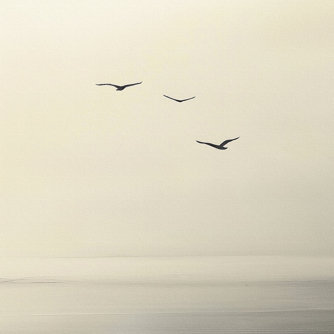 Above the Calm Canvas Art depicts three birds soaring across a softly lit, cloudy sky over a tranquil landscape. This minimalist wall art’s muted tones create a serene atmosphere, ideal for enhancing any modern décor.