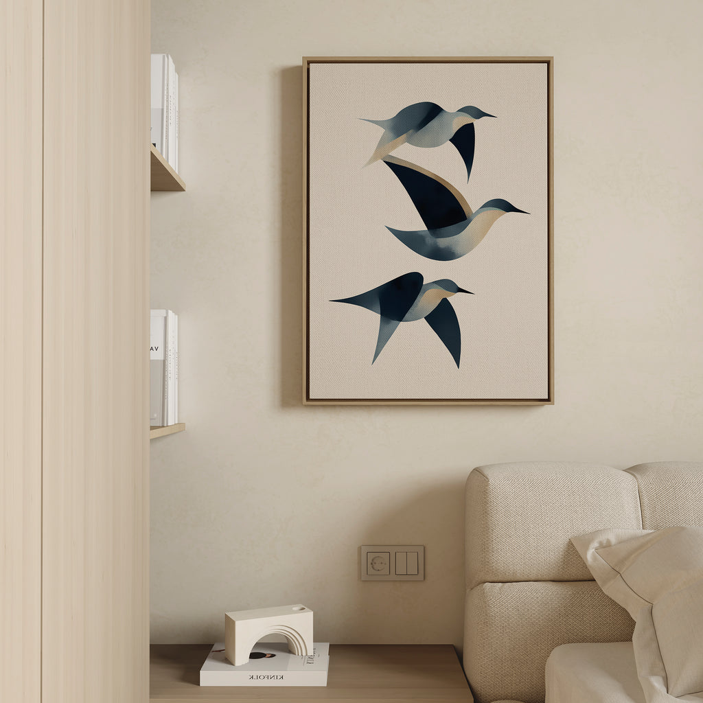 The Abstract Birds in Motion Canvas Art, with blue and beige tones, hangs above a light couch in a minimalist room, creating a serene Nordic Park vibe alongside shelves displaying books and a small white decorative object.