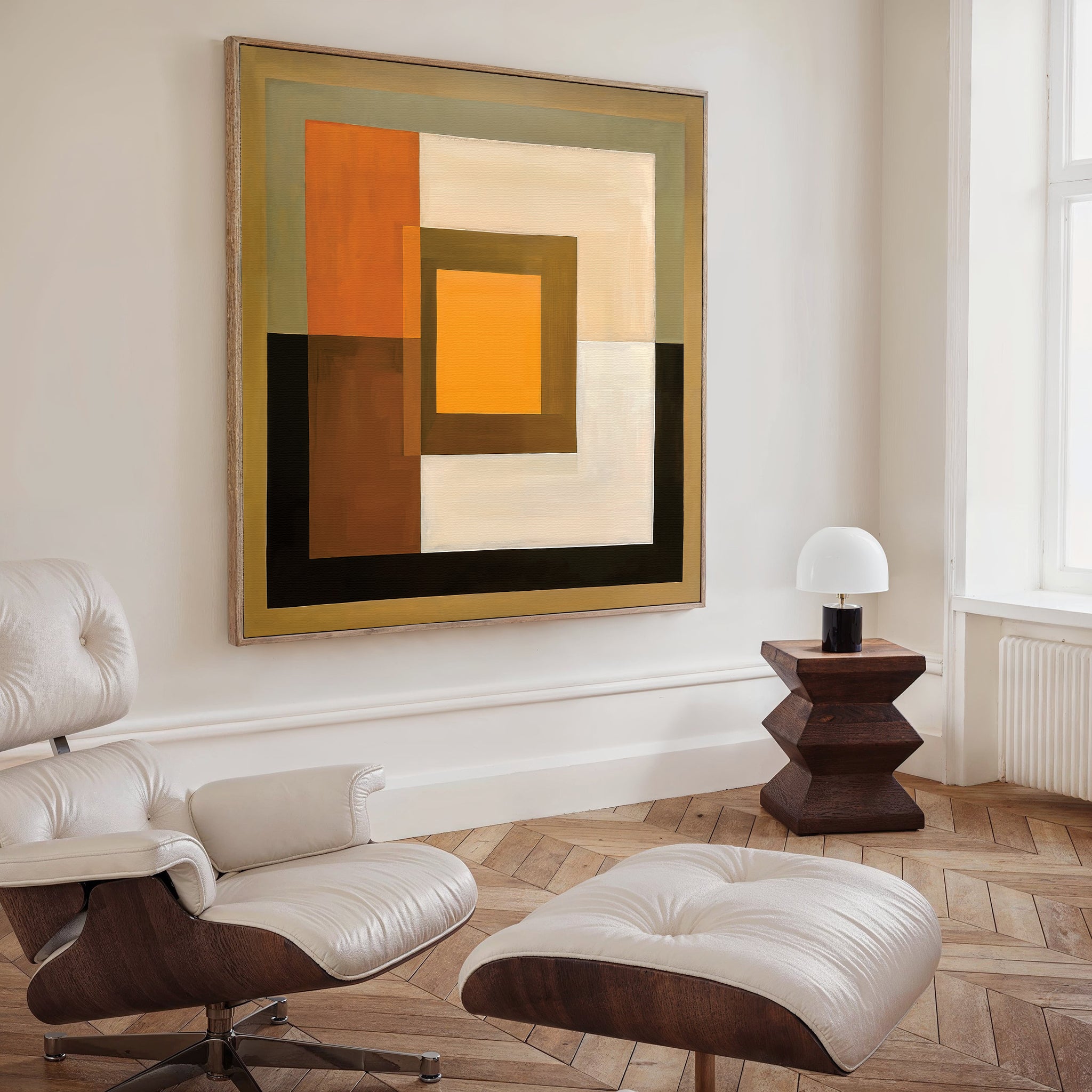 A modern living room featuring a white leather lounge chair and ottoman, a wooden side table with a white lamp, and the Amber Layers Abstract Canvas Art in earth tones displayed on the wall.