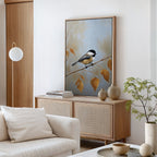 A modern, minimalist living room showcases the Autumn Branch Canvas Art—a Nordic Park-inspired chickadee perched on autumn branches above a light wood sideboard—accented by neutral tones, a white couch, ceramic vases, and a small potted plant.