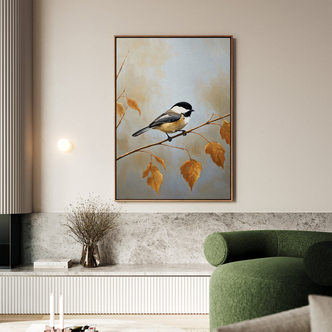 A living room showcases the Autumn Branch Canvas Art depicting a small bird on an autumn branch, displayed above a marble surface with a glass vase of dried flowers and next to a curved green sofa.
