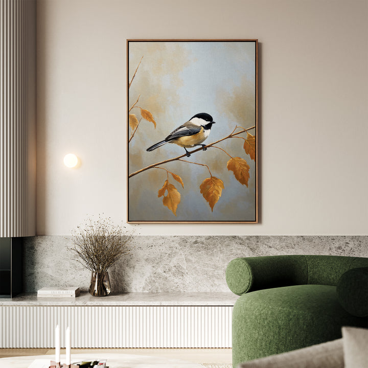 A living room showcases the Autumn Branch Canvas Art depicting a small bird on an autumn branch, displayed above a marble surface with a glass vase of dried flowers and next to a curved green sofa.