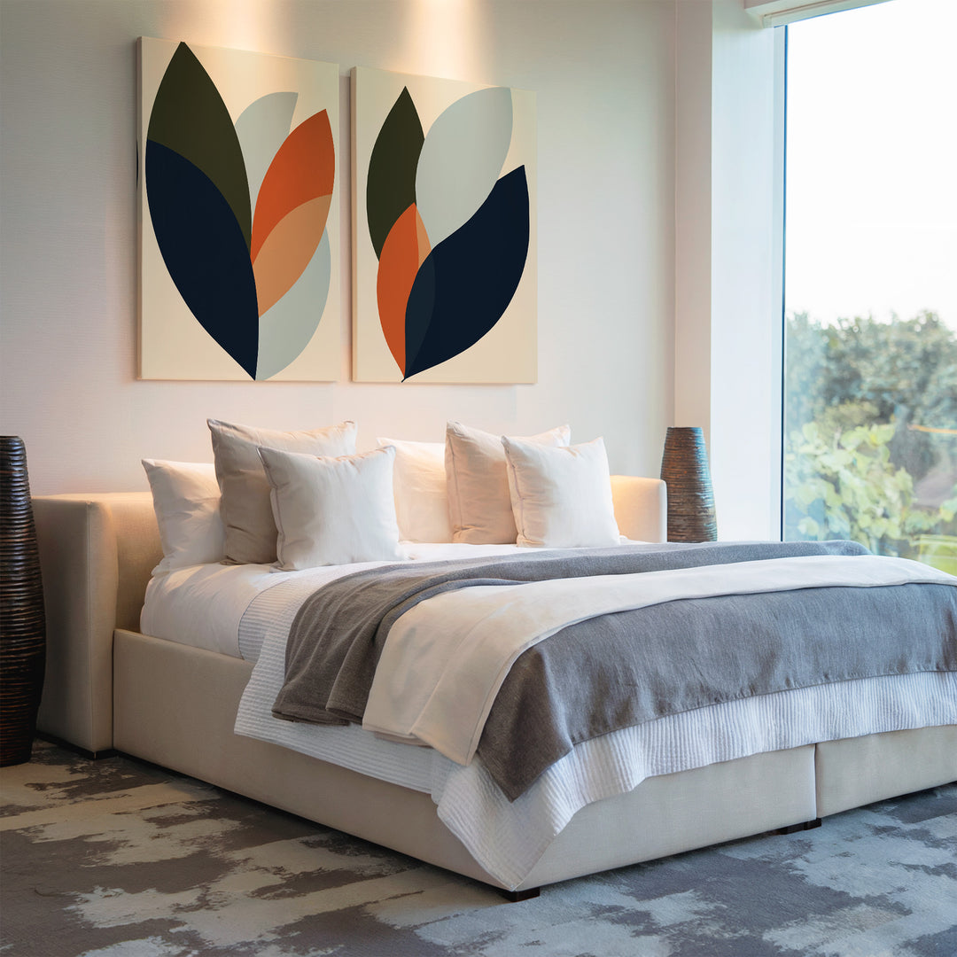 A modern bedroom features a large bed with white and gray bedding, decorative pillows, abstract Autumn Layers Set of 2 wall art above the headboard, tall vases on each side, and a big window overlooking greenery.