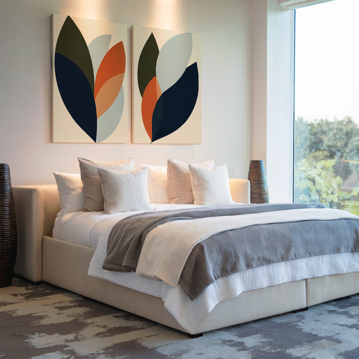 A modern bedroom features a large bed with white and gray bedding, decorative pillows, abstract Autumn Layers Set of 2 wall art above the headboard, tall vases on each side, and a big window overlooking greenery.
