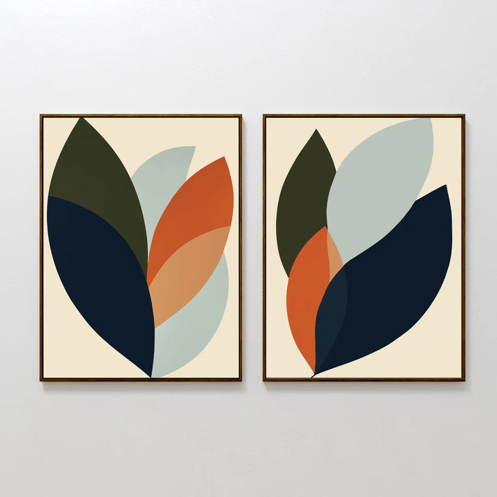 The Autumn Layers Set of 2 features framed abstract prints with overlapping leaf shapes in dark green, navy, orange, and light blue on cream—ideal modern wall art for your living room. Display side by side on a white wall.