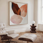 A modern living room with wooden herringbone floors, a white leather lounge chair and ottoman, a geometric wooden side table with a small white lamp, and striking Autumn Petals Canvas Art featuring abstract earthy-toned leaf shapes.