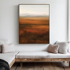 A minimalist living room features light-colored cushioned benches, pale throw pillows, and the Autumn Plains Abstract Canvas Art in warm brown and orange tones hanging on a white wall.