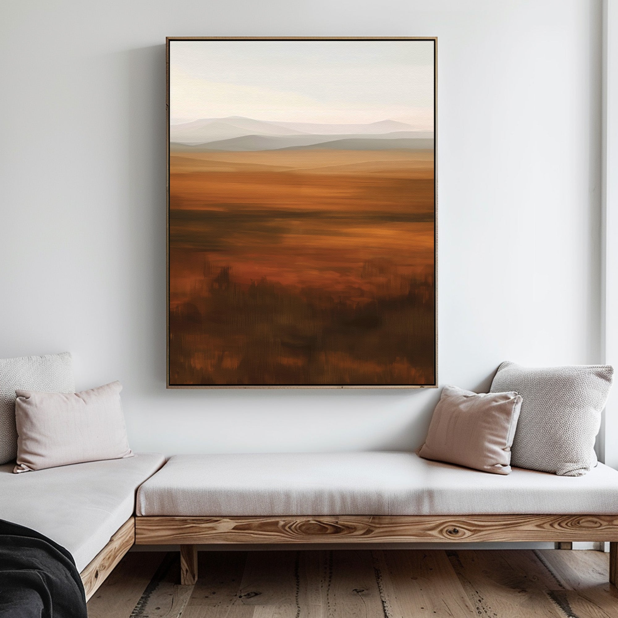 A minimalist living room features light-colored cushioned benches, pale throw pillows, and the Autumn Plains Abstract Canvas Art in warm brown and orange tones hanging on a white wall.