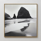 The Basalt Beach Canvas Art is a black-and-white framed painting of rocky sea stacks reflected in wet sand under misty skies—an ideal minimalist coastal decor piece for modern bedroom wall art collections.