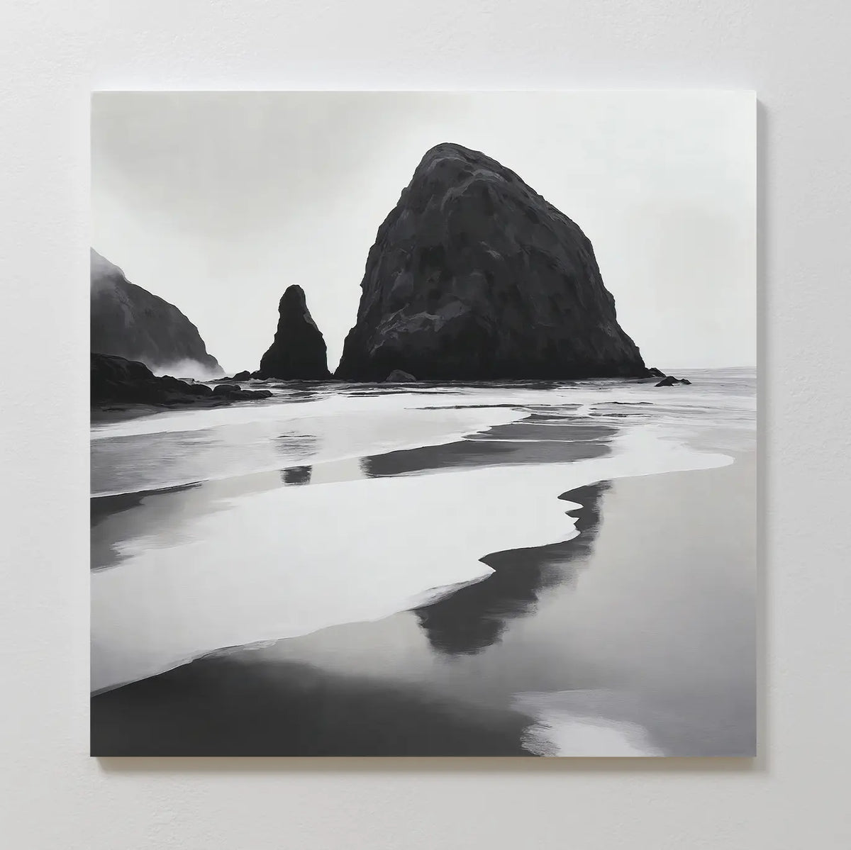 Basalt Beach Canvas Art features black and white wall art of a rocky coast with sea stacks reflected in wet sand under cloudy skies. This minimalist piece adds a calm, moody touch to modern bedrooms and looks stunning on a white wall.