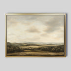 Beneath The Clouds Canvas Art is a large framed wall piece featuring rolling hills and fields under a cloudy sky in soft green, brown, and beige tones, set against a gray background for a minimalist look.