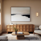 A modern living room with neutral tones features a wooden sideboard, the Binary Calm Abstract Canvas Art – Horizontal above it, a light-colored sofa, a wooden coffee table with a vase of flowers, and a soft beige rug.