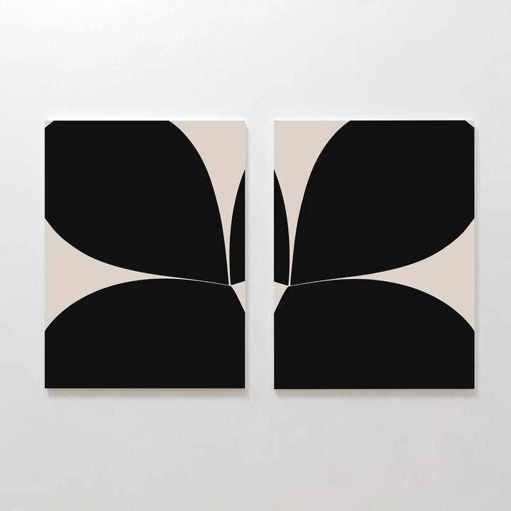 The Minimal Petal Set of 2 features abstract black and beige canvases with bold, curved shapes meeting at the center, forming a symmetrical geometric design—ideal minimalist wall art for modern spaces.