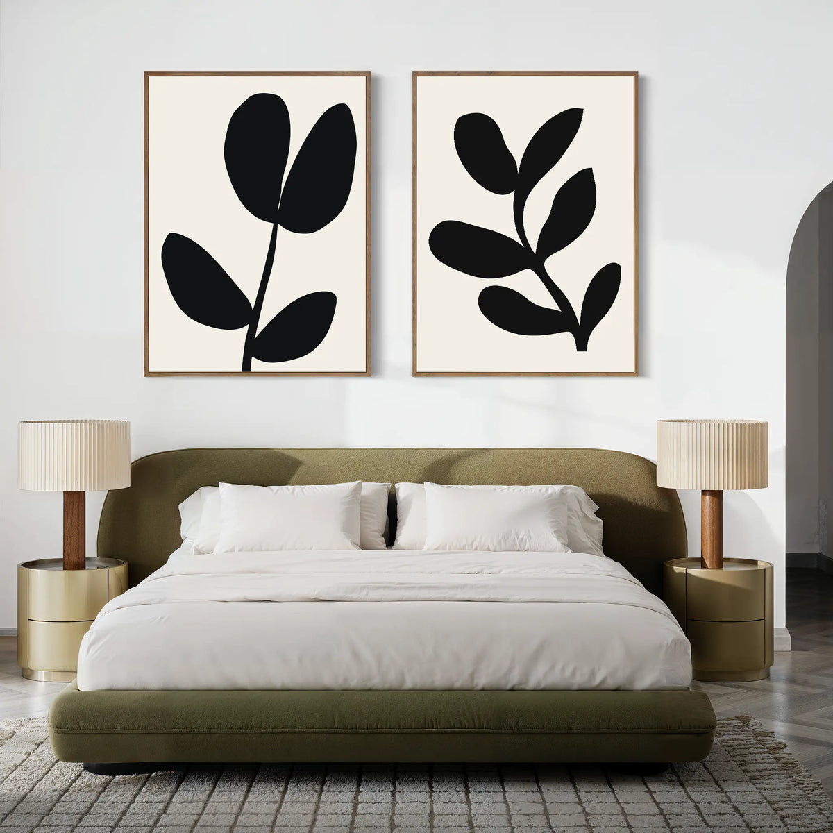 A modern bedroom with a low olive green bed, two round beige nightstands topped with matching lamps, and the Black Leaf Set of 2 minimalist prints hanging above the bed on a crisp white wall.