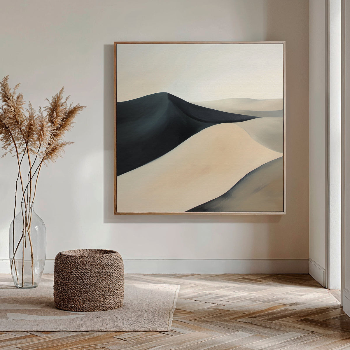 A modern, minimalist room with light walls and herringbone floors features the Black Veil Abstract Canvas Art. A glass vase with pampas grass and a woven basket complete the living room decor as natural light streams in.