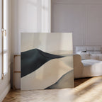 The Black Veil Abstract Canvas Art, a large minimalist piece depicting abstract forms, leans against the wall in a bright modern living room with parquet floors, a white sofa, and sunlight streaming through tall windows.