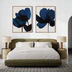 A modern bedroom with an olive green bed, white bedding, two beige nightstands with matching lamps, and the Bloom Set of 2 contemporary floral wall art in blue shades displayed above the bed on a crisp white wall.
