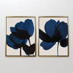 The Bloom Set of 2 features framed art prints with abstract dark blue and black floral silhouettes on a light beige background, adding modern elegance to any space when displayed side by side.