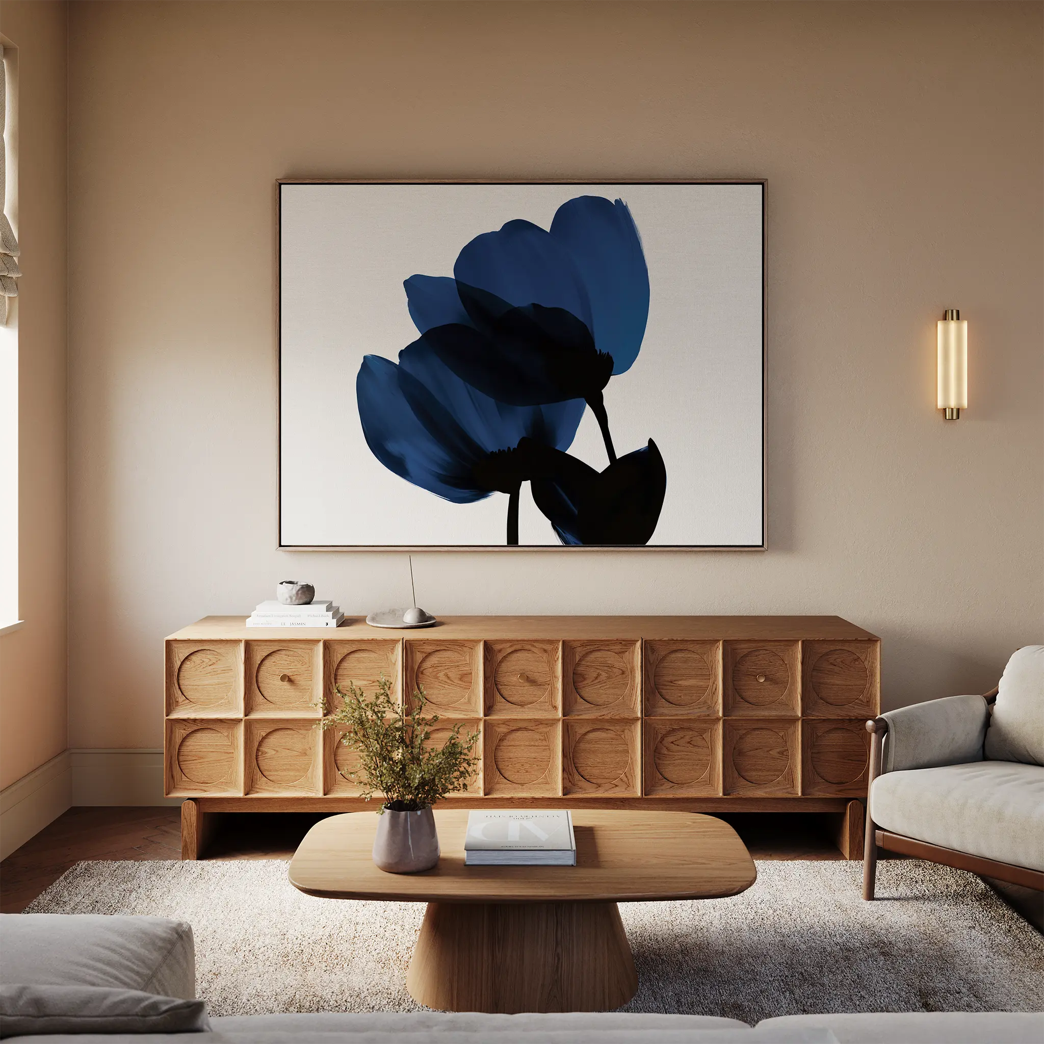 A cozy living room with neutral sofas, a modern wooden sideboard, a round coffee table, and the Bloom Abstract Canvas Art – Horizontal featuring blue flowers. Soft lighting and a small plant add warmth to the inviting decor.