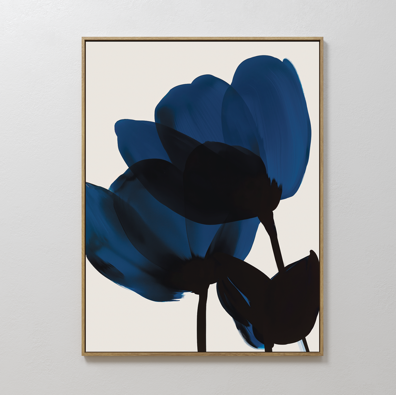 The Bloom Abstract Canvas Art features two dark blue abstract flowers with black stems on a light beige background, framed in thin gold—a perfect minimalist piece for modern living room decor.