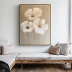 The Blossom Trio Abstract Canvas Art, featuring three white flowers with long stems, hangs above a wooden bench with neutral cushions in a minimalist living room.