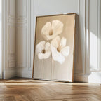 The Blossom Trio Abstract Canvas Art, featuring three white flowers with delicate petals, leans against a white paneled wall on a wooden floor, adding minimalist elegance and style to this bright room.