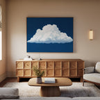 A cozy living room with beige sofas, a modern wooden sideboard, and coffee table. The Blue Horizon Cloud Canvas Art hangs above the sideboard for minimalist appeal. A small plant and decor books sit on the table and sideboard.