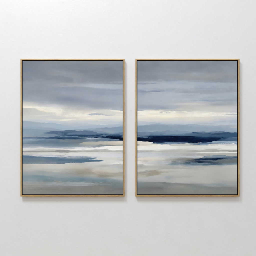 The Blue Mist Horizon Set of 2 features large abstract landscape prints in soft blue, grey, and beige. These framed canvases evoke a serene, cloudy sky, adding calming, minimalist decor to your living room when hung side by side.