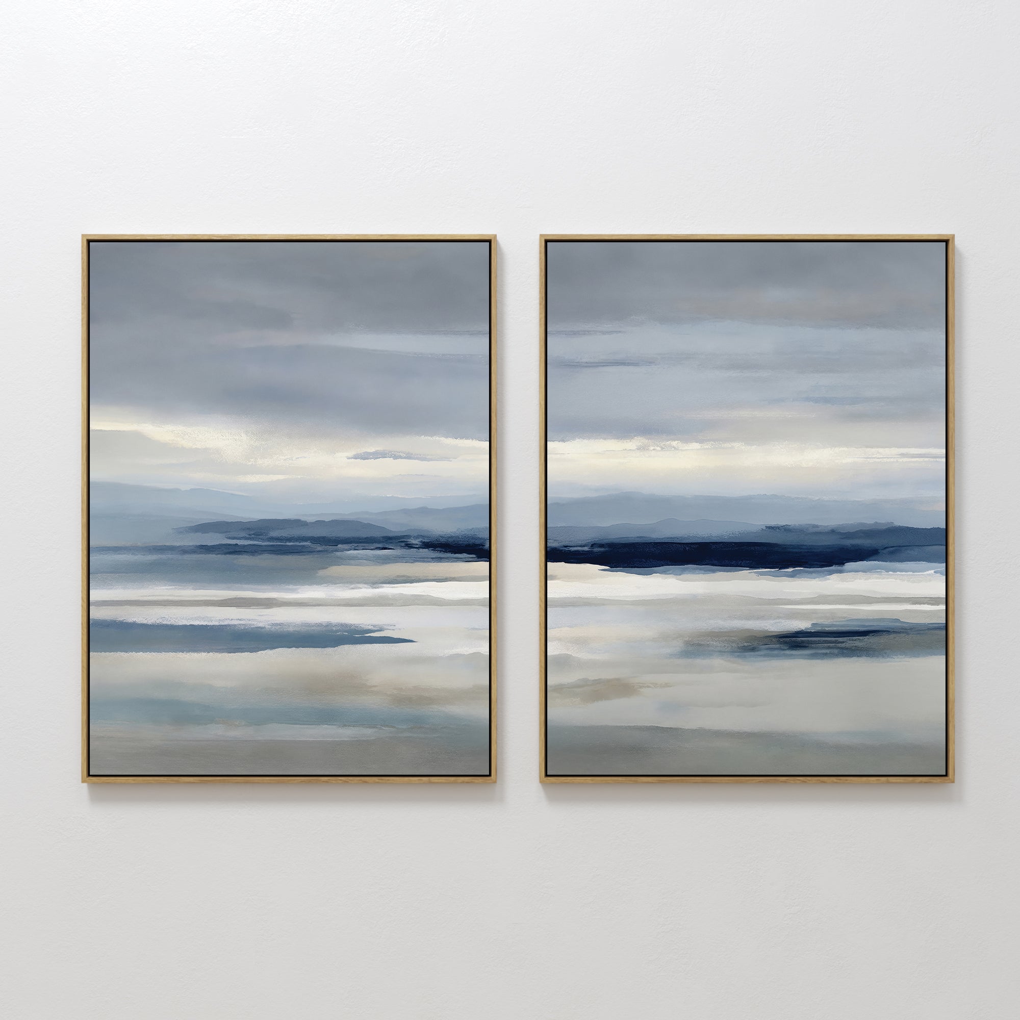 The Blue Mist Horizon Set of 2 features large abstract landscape prints in soft blue, grey, and beige. These framed canvases evoke a serene, cloudy sky, adding calming, minimalist decor to your living room when hung side by side.