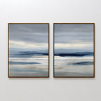 The Blue Mist Horizon Set of 2 features framed, minimalist abstract landscapes in layered blue, gray, and beige. These large canvas prints resemble misty water and distant mountains, perfect as modern wall art for living room decor.