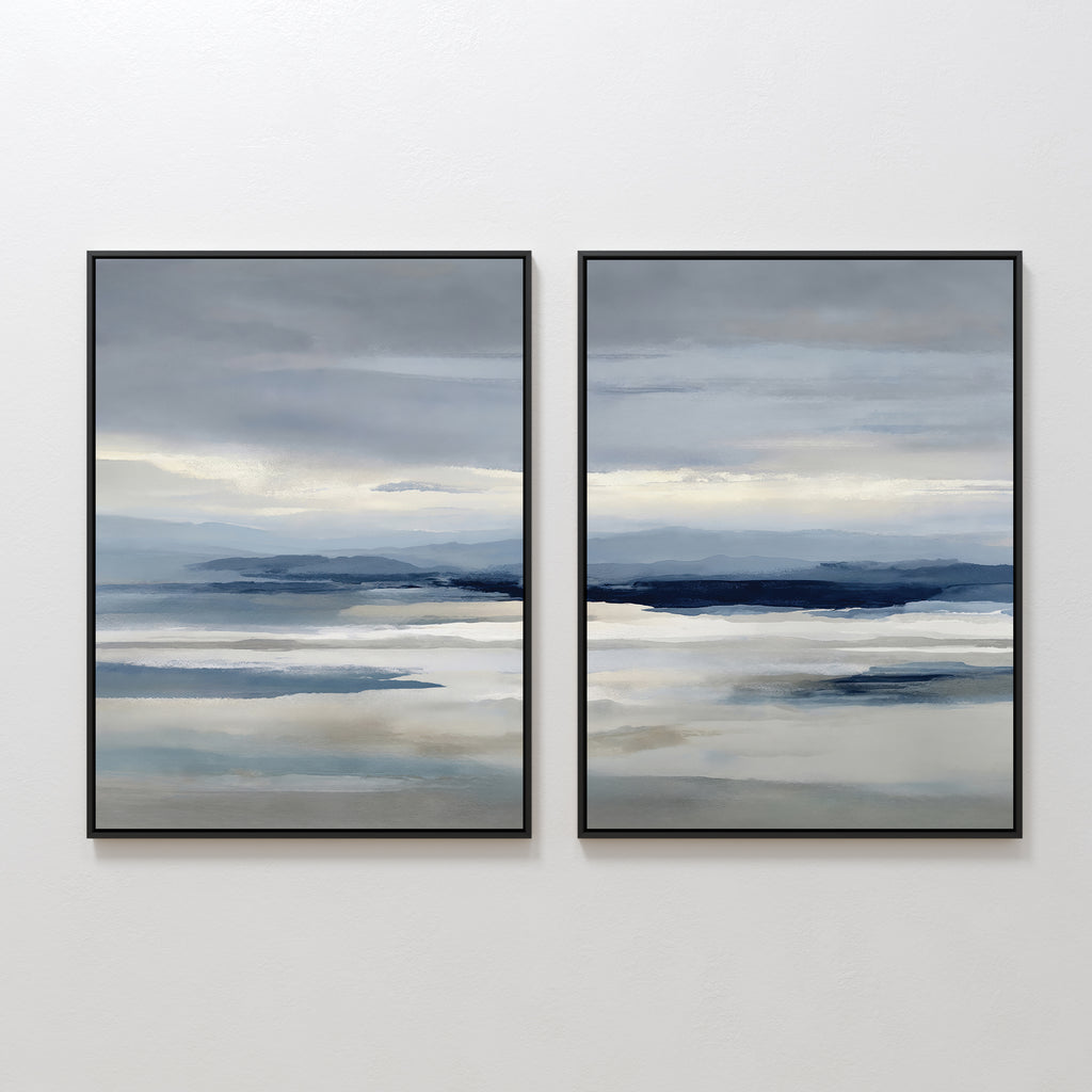 The Blue Mist Horizon Set of 2 features abstract landscape prints in soft blue, gray, and beige. These large canvases create a serene seascape, perfect as minimalist wall art for your living room, displayed side by side on a white wall.