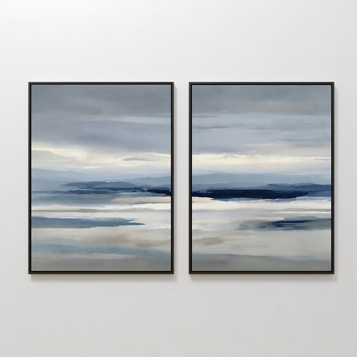 The Blue Mist Horizon Set of 2 features abstract landscape prints in soft blue, gray, and beige. These large canvases create a serene seascape, perfect as minimalist wall art for your living room, displayed side by side on a white wall.
