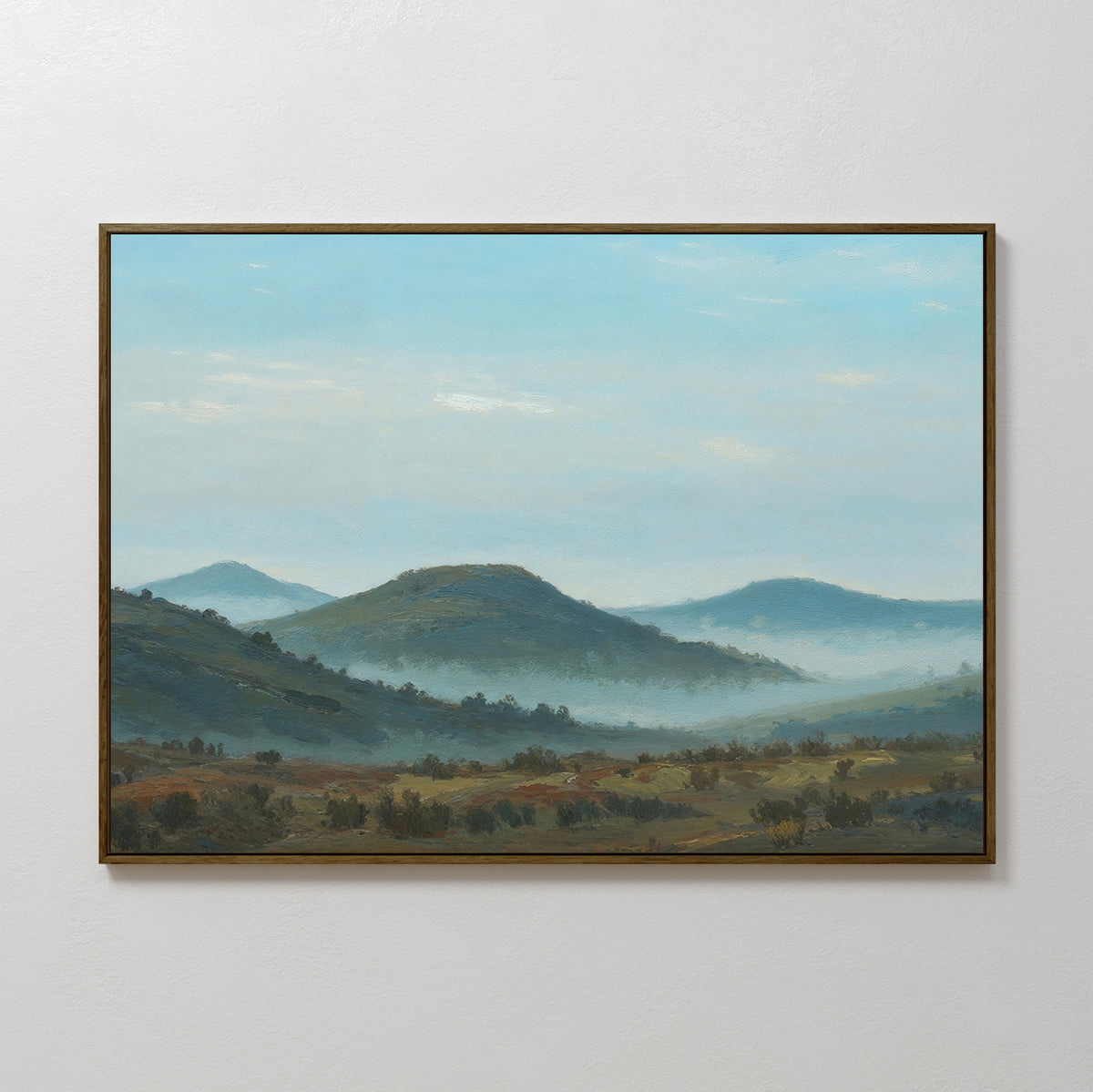 Blue Ridge View Canvas Art features rolling green hills, distant mountains, and a misty valley under a blue sky, adding tranquil charm to your bedroom decor on a plain white wall.