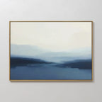 Blue Valley Mist Canvas Art, featuring blurred blue and white tones that evoke a misty seascape, hangs on a plain white wall—an ideal piece for minimalist decor.