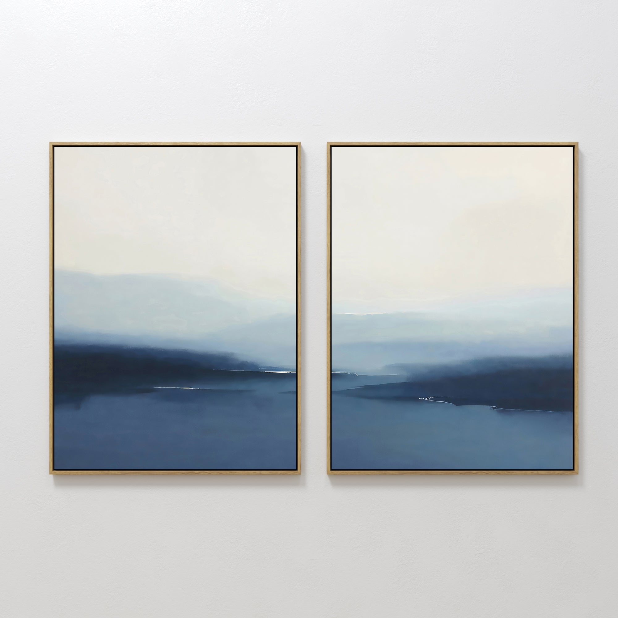 The Blue Valley Mist Set of 2 features framed abstract paintings with soft blue and white gradients, evoking misty horizons. Ideal as minimalist wall art decor, these prints add a serene touch to any room.