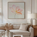 A modern living room featuring a white sofa with beige cushions, side table and lamp, dried flowers in a vase, and the Blush Magnolia Canvas Art—an eye-catching large pink floral painting—hanging above the sofa.