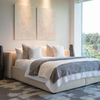 Modern bedroom with a large bed in white and gray bedding, several pillows, the Blush Sketch Set of 2 minimalist wall art above the headboard, tall vases on each side, and a large window filling the space with natural light.