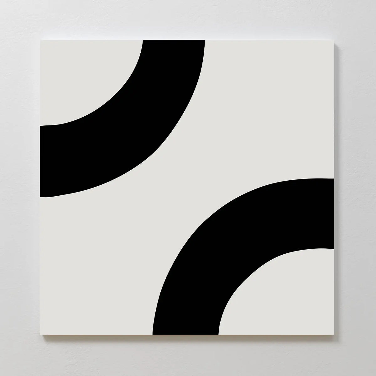Bold Orbit Canvas Art showcases two thick black curved arcs on a white square canvas, each partially visible at opposite corners, creating a striking minimalist geometric design ideal for modern interiors.